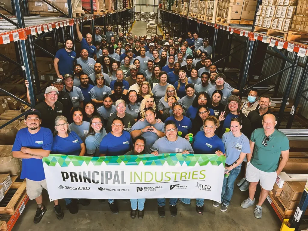 Professional group photo of the Principal Industries team at the company's manufacturing and distribution facility.