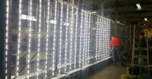 Large sign cabinet illuminated with vertical LED light strips during installation or testing.