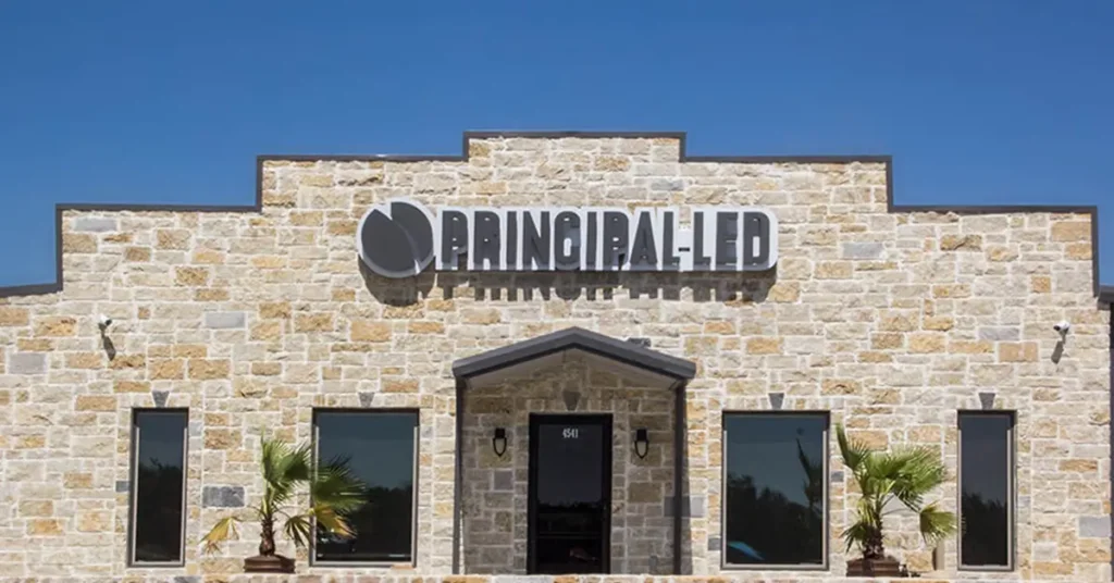 Principal LED corporate facility with stone exterior and illuminated building sign.