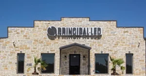 Principal LED corporate facility with stone exterior and illuminated building sign.
